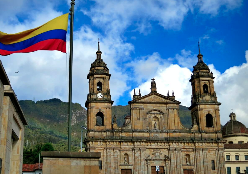 photograph of the Colombian flag flying over Bogota under a blue sky
