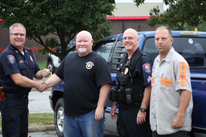 Roeland Park Police Chief John Morris (left) is handed keys to pickup by Blake Breeden of Boulevard Tires. Sgt. Randy Costlow and Richard Moffett of Benfers Tow also were on hand.