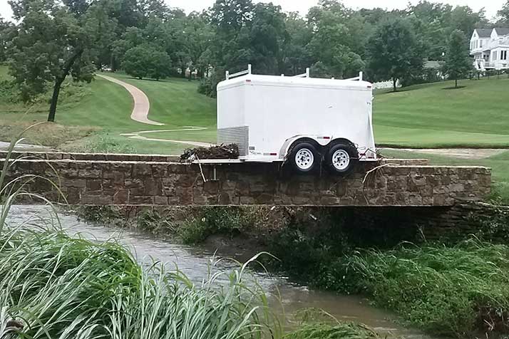 Flash flooding washed trailer belonging to Boy Scout Troop 192 at Old Mission United Methodist from the church parking lot and onto a golf cart bridge at Kansas City Country Club. Photo by Jim Poplinger.