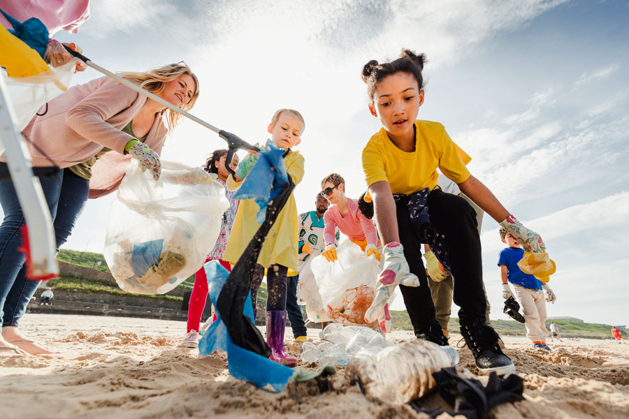 Families filling up bag full of trash on beach
