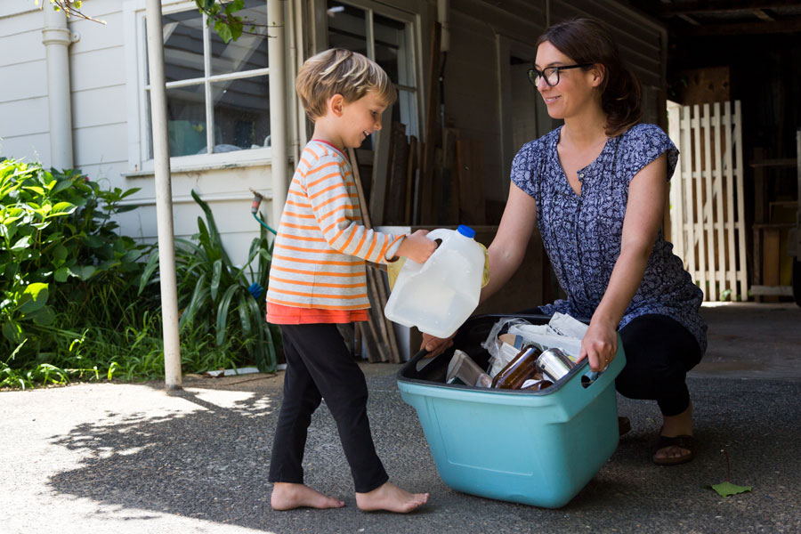 Toddler cleaning up plastic with mom helping