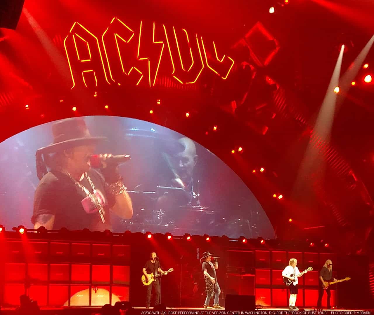 AC/DC with Axl Rose performing at the Verizon Center in Washington, D.C. for the "Rock or Bust Tour" on September 17, 2016. On stage from left to right: Stevie Young, Axl Rose, (obscured behind Axl but visible on the monitor, Chris Slade), Angus Young, and Cliff Williams