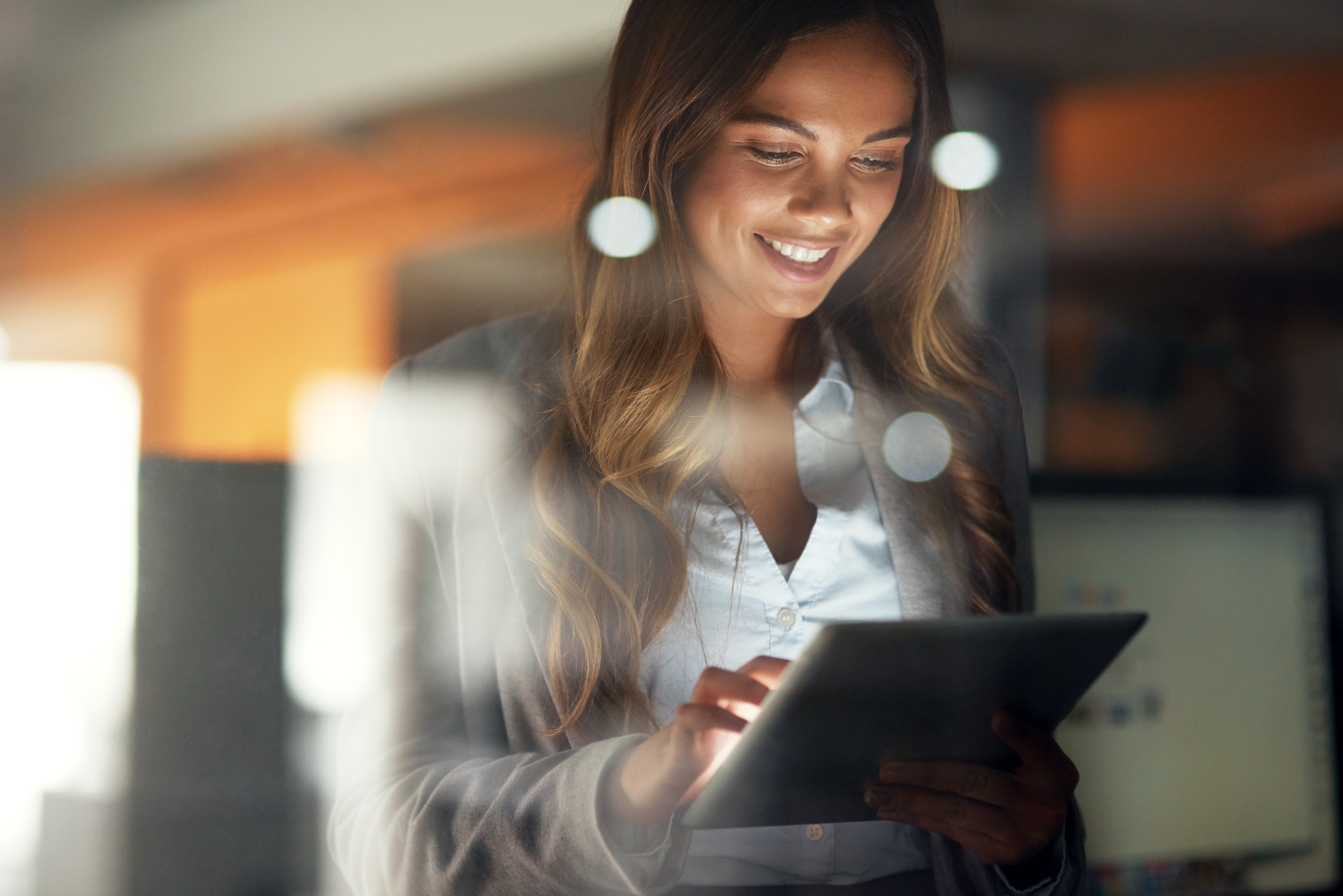 Woman smiling and looking at a tablet