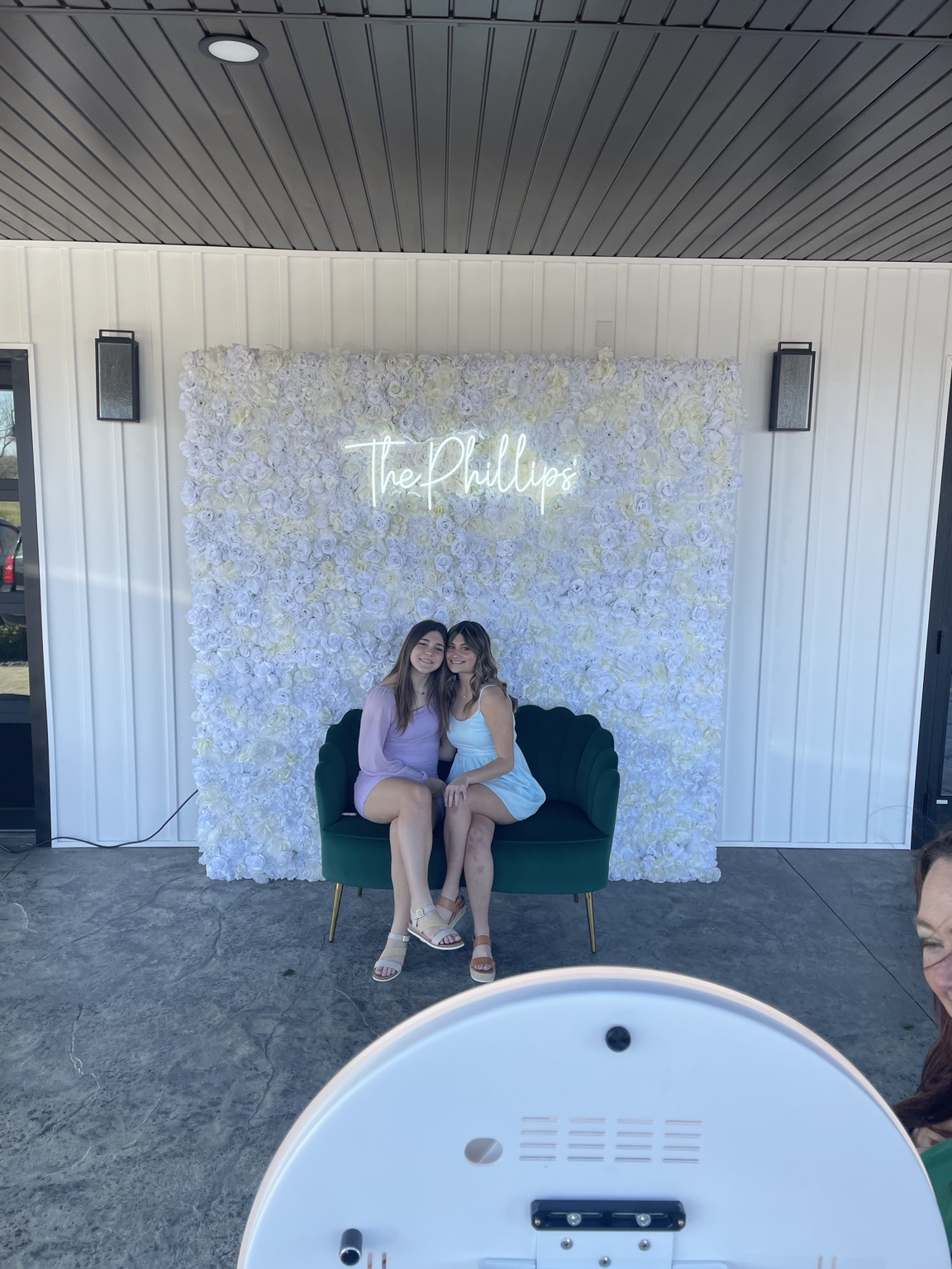 Guests enjoying a Raspy Media Photo Booth with a flower wall backdrop