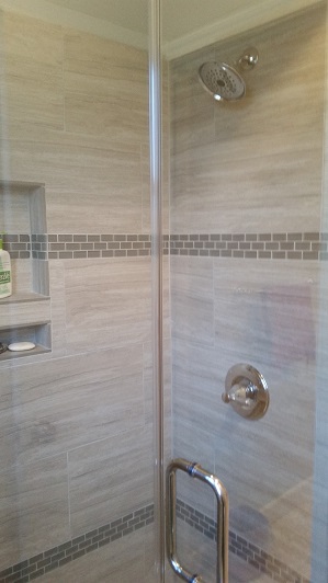 Sugar Land walk-in shower replaced a fiberglass bathtub located in the toilet area, with little space to work with. A custom frameless shower door with chrome trim gave the finishing touch to the tiled area with bench seat and soap niche.