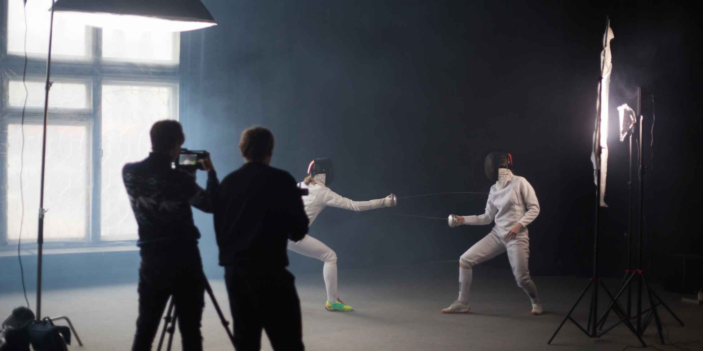 Photographers capturing two people fencing