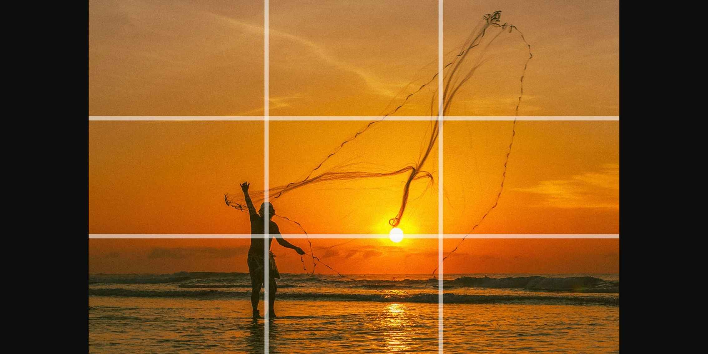 Silhouetted fisherman casting a net at sunset, with the sun positioned in the rule of thirds grid Silhouetted fisherman casting a net at sunset, with the sun positioned in the rule of thirds grid