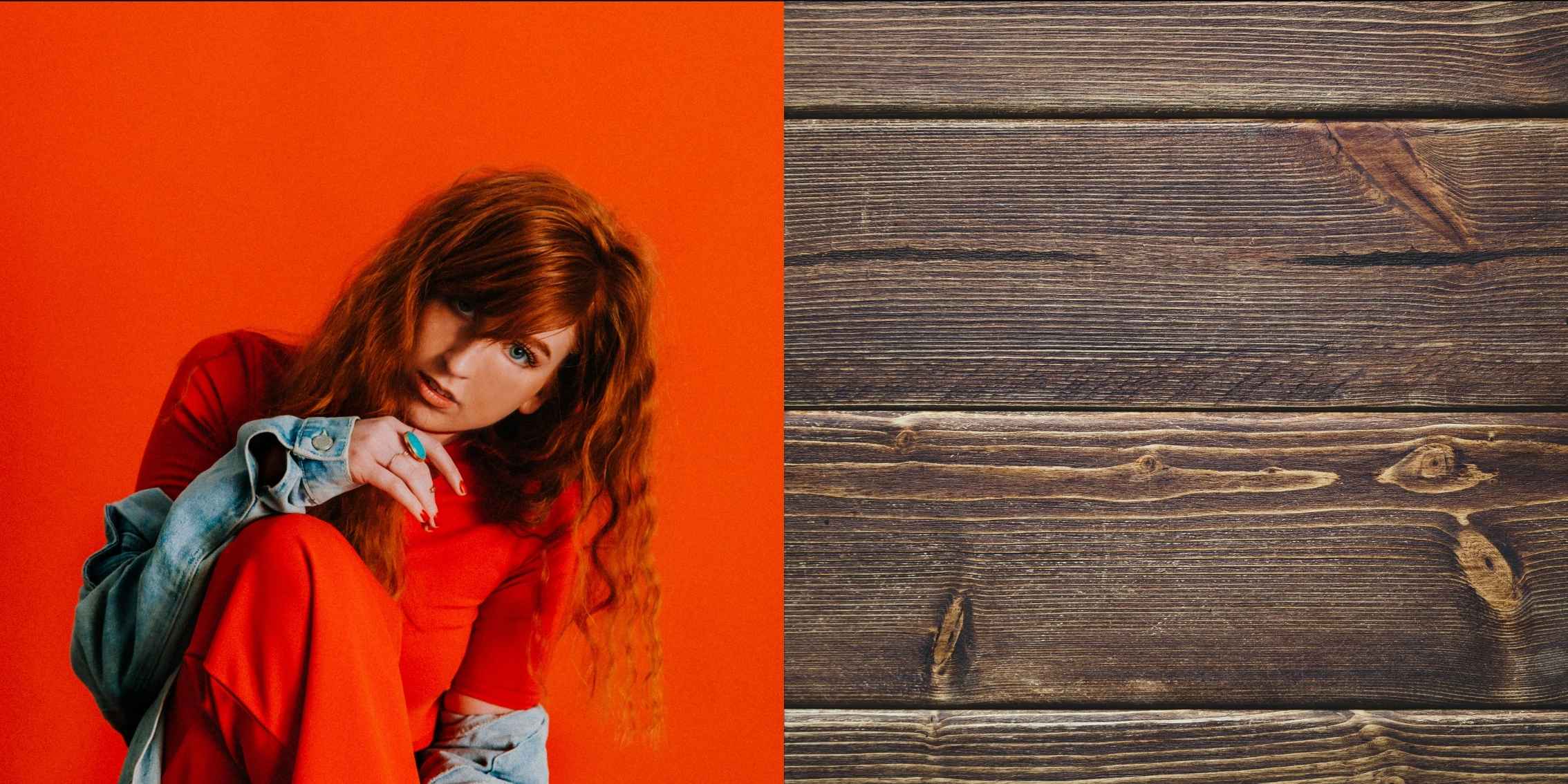 Red headed lady photographed in front of an orange backdrop