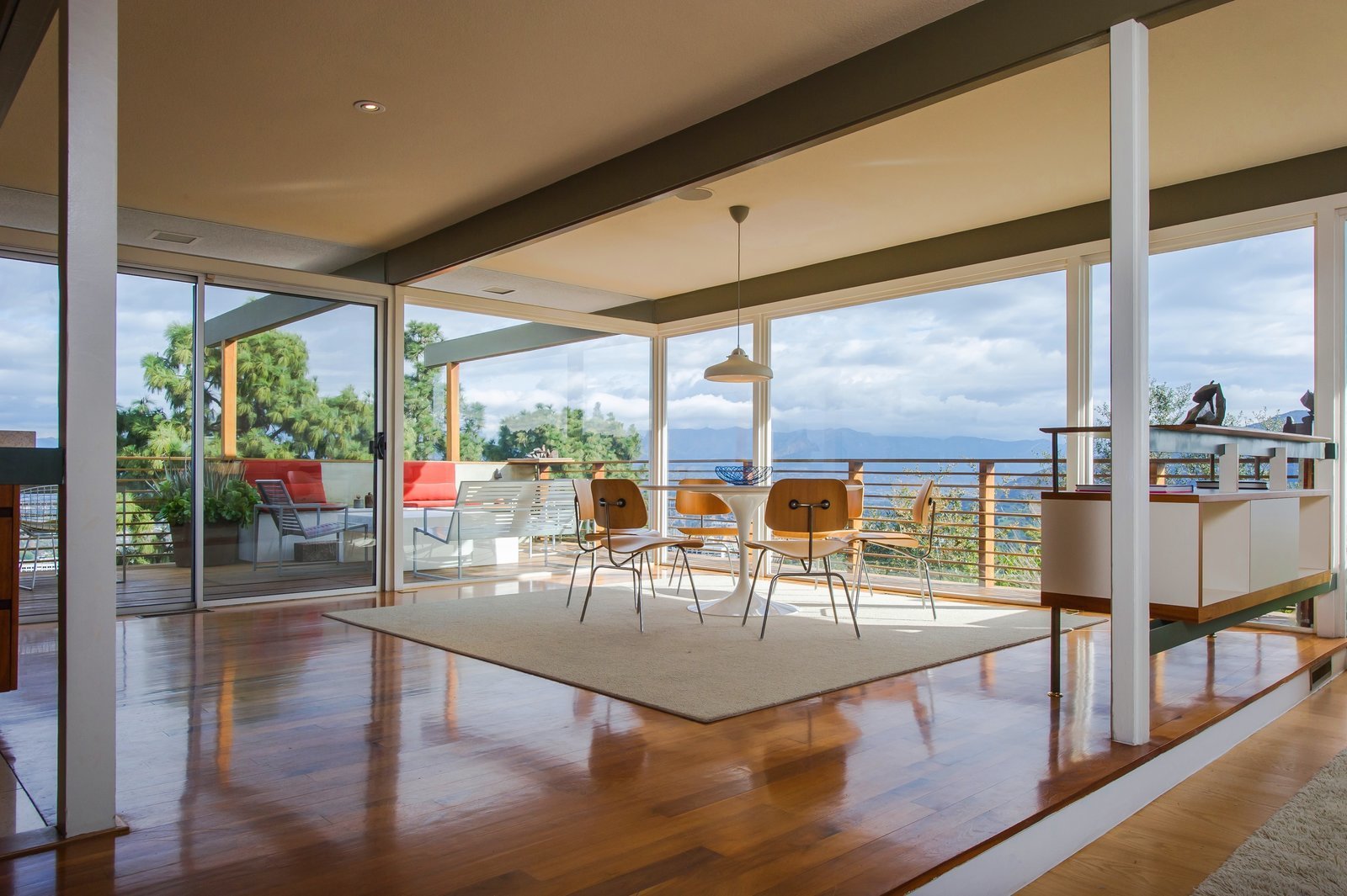 A room surrounded by floor-to-ceiling windows with a view of the mountains.