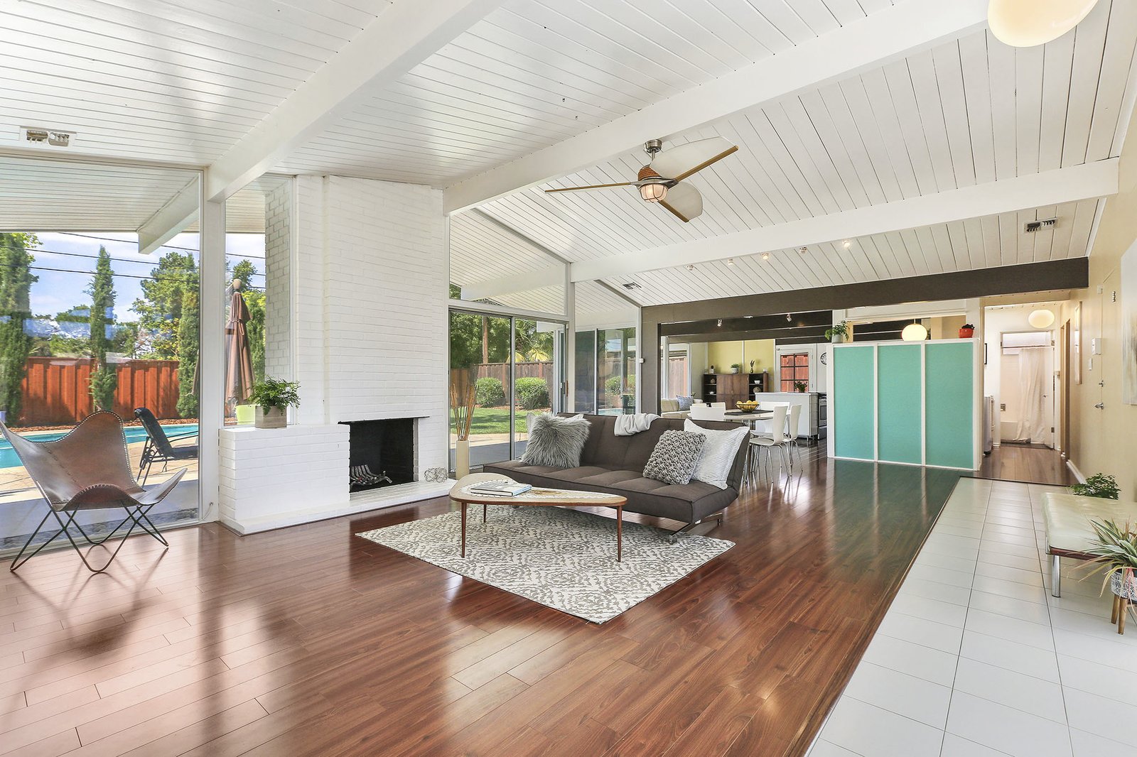 A large open room with couch, coffee table and chair and high ceilings.