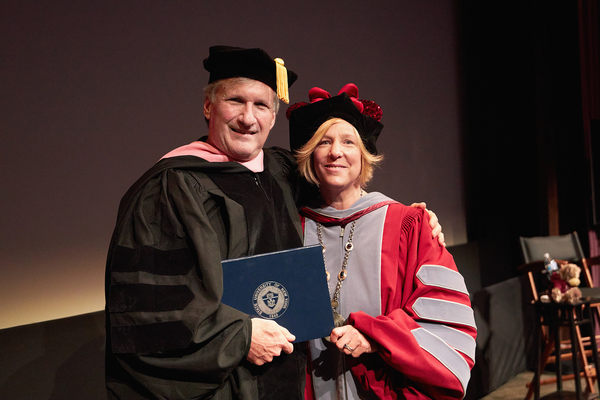 At left, David Fluhr (Hon. ’79) receives his honorary Doctor of Music degree from SUNY Potsdam President Dr. Suzanne R. Smith, during a special ceremony held at the Burny Mattinson Theater at Walt Disney Animation Studios in Burbank, Calif.