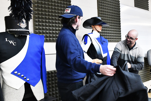 Lindsey Wilson University Director of Bands Robert Palmer, right, gets help from percussionist Noah Mudd ’27 of Louisville, Kentucky, to reveal the new uniform for Lindsey Wilson Blue Raider Band on Wednesday, March 18, in the Blue Raider Band Building. The new uniform will make its debut at the Lindsey Wilson football team’s first 2026 home game at Parnell Family Stadium, which will be announced later this year.