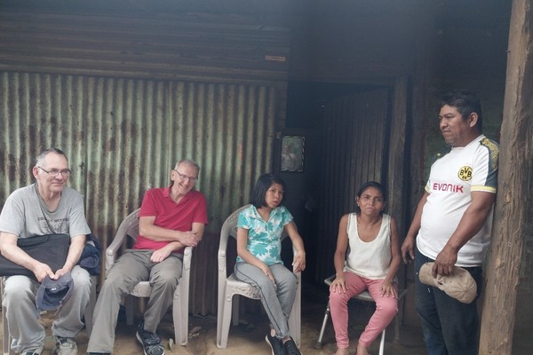 Dr. Steven Granich (far left), volunteer social worker, and Adrian Yeoman, volunteer physical therapist from England (second from left), visiting the home of a young woman and her family in Nicaragua. 