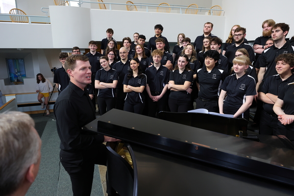 Wartburg College commissioned Dan Forrest (center) to create an arrangement of "O Holy Night" that premiered at the 2025 Christmas with Wartburg. He visited campus in March to accompany the Wartburg Choir in a video recording of the piece. 