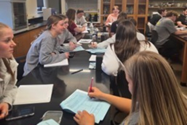 Commonwealth University-Lock Haven students engaged in pre-lab discussion and worksheet analysis, preparing to understand real-time PCR concepts and experimental design.
