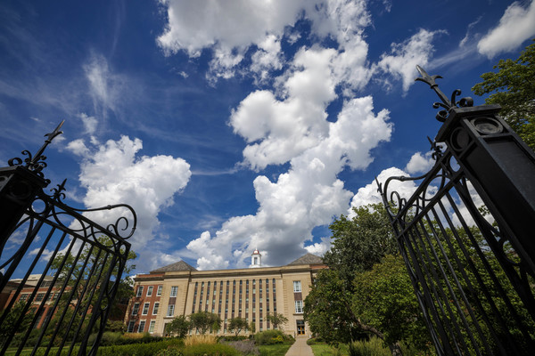 Love Library South is framed by black metal gates on a partly cloudy day.
