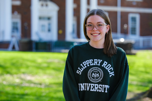 Woman in SRU sweatshirt standing in campus quad