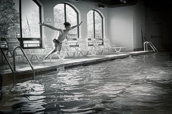 Black and white photo of child jumping into a pool by GCC student Savannah LaPierre