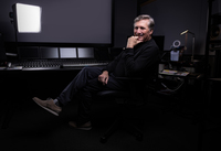 A man poses for a photo at a sound mixing station.