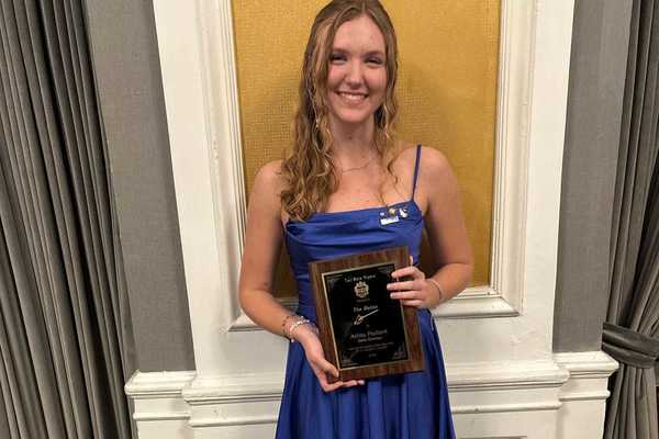 Ashley Paulisick holds the Baton Award.