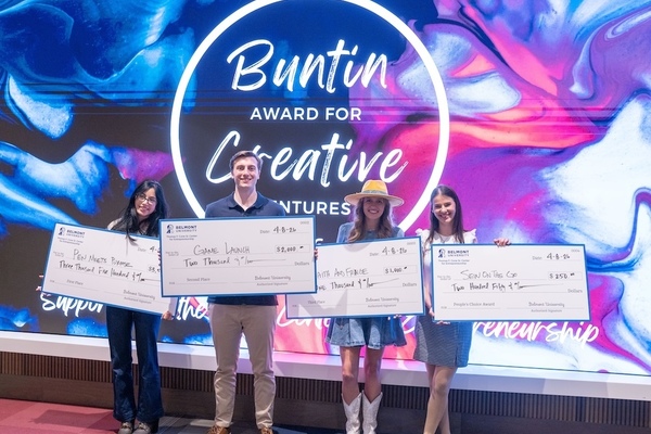 Students holding large checks