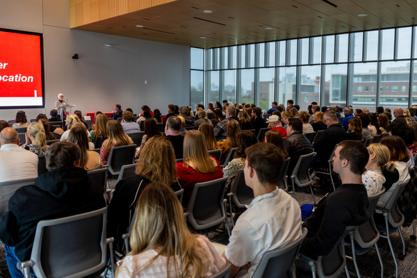 Marjorie Kostelnik, emeritus dean of the College of Education and Human Sciences, speaks at a lectern to a large, seated crowd.