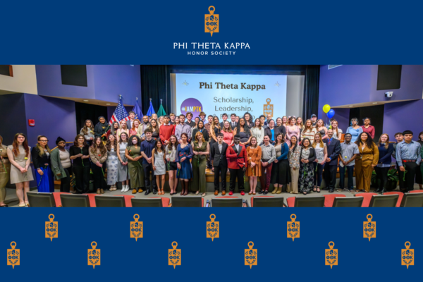 Group photo of Phi Theta Kappa inductees on a stage.