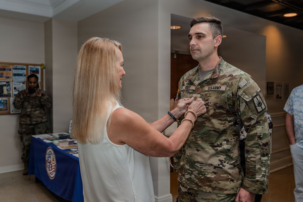 New York Army  National Guard Major Corey Root, human resources division staff officer with the 53rd Troop Command is promoted during a ceremony conducted at Camp Smith Training Site, near Peekskill, N.Y., April 17, 2026. His mother, Leslie, pins him with his new rank. (U.S. Army National Guard photo by Sgt. 1st Class Sebastian Rothwyn)