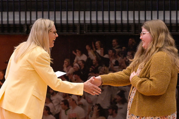 Two women shake hands.