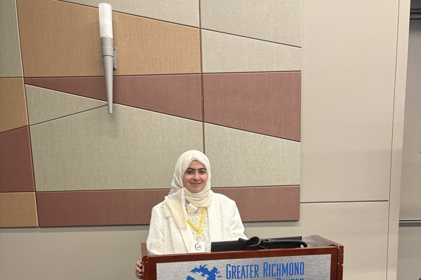 woman stands behind podium