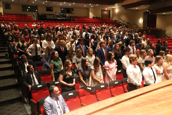 A crowd sits in a theater during an honors ceremony.
