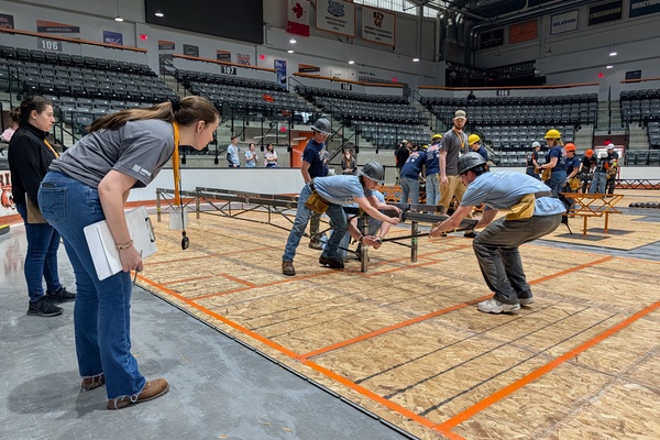 The SUNY Canton Steel Bridge Team constructs their bridge during a regional competition held recently at Rochester Institute of Technology. Build team members Ciara McDougal of Gouverneur, Ryan Willard of Hermon, George Staats of Essex, and Mitch Timerman of La Fargeville, assemble the bridge in front of judges and onlookers.   