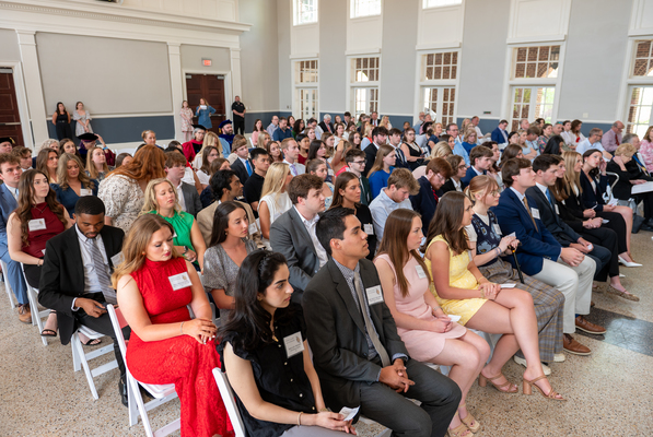 Seated students attend a ceremony in their honor.