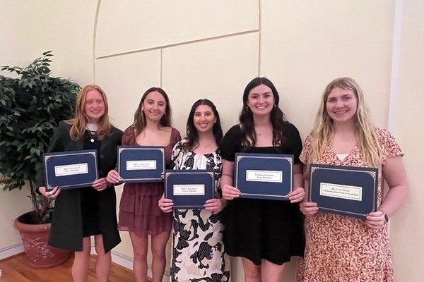 Five students hold award certificates. 