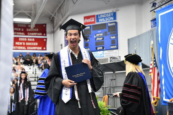 Luis Patrick Groff-Hinojosa of Henderson, Nevada, who graduated with a bachelor of arts in mathematics, flashes a big smile after receiving his degree from Lindsey Wilson University President William T. Luckey Jr. Lindsey Wilson awarded 504 degrees to its spring class. The university’s 123rd commencement celebration was held in three ceremonies, May 1-2, in Biggers Sports Center.  