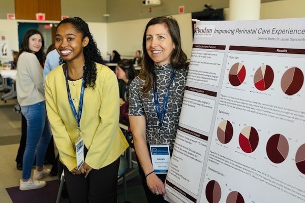 SUNY Potsdam student Destinee Baxter ’26 (left) presents on her project, “Improving Perinatal Care Experiences in St. Lawrence County,” along with faculty mentor Dr. Lauren Diamond-Brown, at the 2026 SUNY Undergraduate Research Conference.