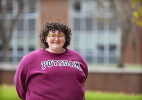 Chase Bond poses in a SUNY Potsdam sweatshirt on the Academic Quad.