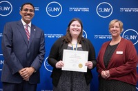 Chancellor King, Molly Collins and President Smith pose in front of a SUNY backdrop.