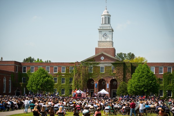 Graduates and families gather in front of the Satterlee Hall clocktower in the Academic Quad during Commencement.