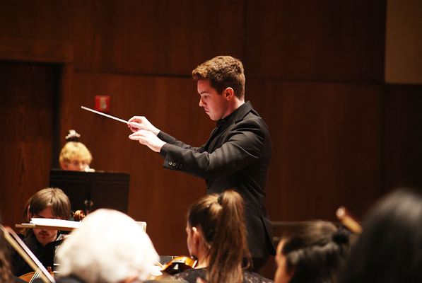 Image of Benton Donahue conducting an orchestra.






