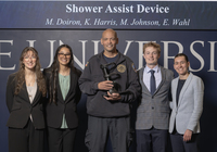 Four students with paramedic Ben Masten, who is holding the prosthetic they created for him