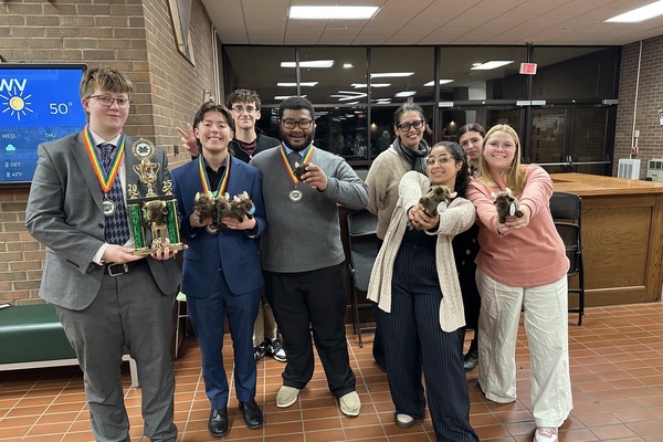 Debate Team students hold awards.