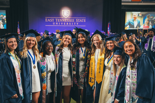 ETSU graduates pose on the Commencement floor. 