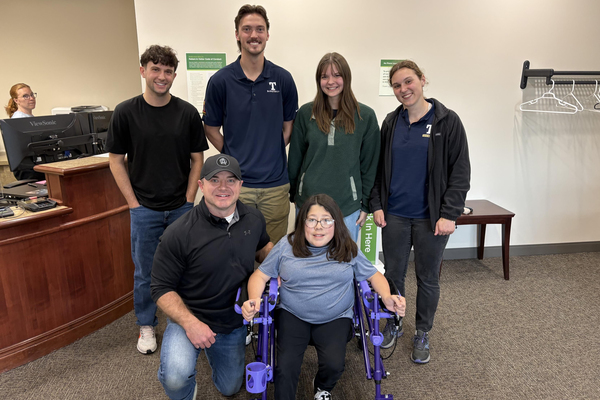 Back, from left, Trine University biomedical engineering students Liam Millership, Colin Shriver, Hannah Knost and Elizabeth Larson designed a custom pediatric walker for Sophia Dillon, pictured in the foreground with her father, Rob.