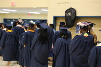 A line of graduates from the back processing in to be seated.