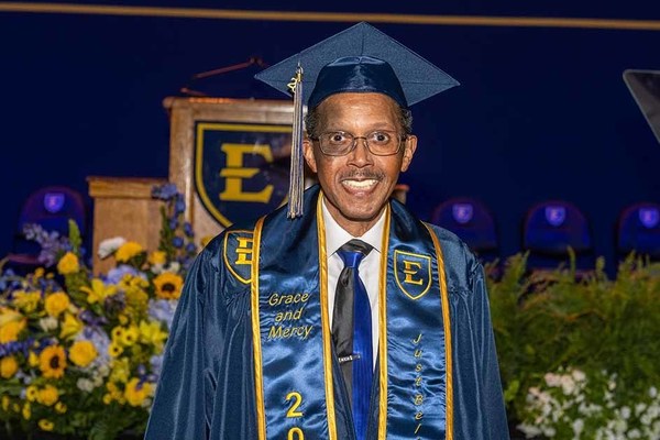 ETSU graduate Homer Eugene Henley Jr. poses in cap and gown during commencement.