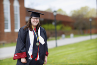 Molly Collins poses in a cap and gown in the Academic Quad.