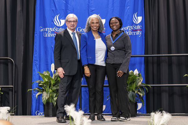 Paul Alberto, Felicia Mayfield and Ramziah Mansaray pose for a photo on stage at the college's 2026 Scholars Recognition Luncheon.