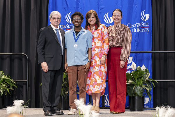 Paul Alberto, Jordan Little, Melissa Sturgis and Lanie Sturgis pose for a photo on stage at the college's 2026 Scholars Recognition Luncheon. 