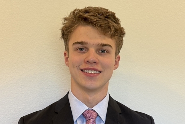 student headshot wearing black suit jacket and red tie